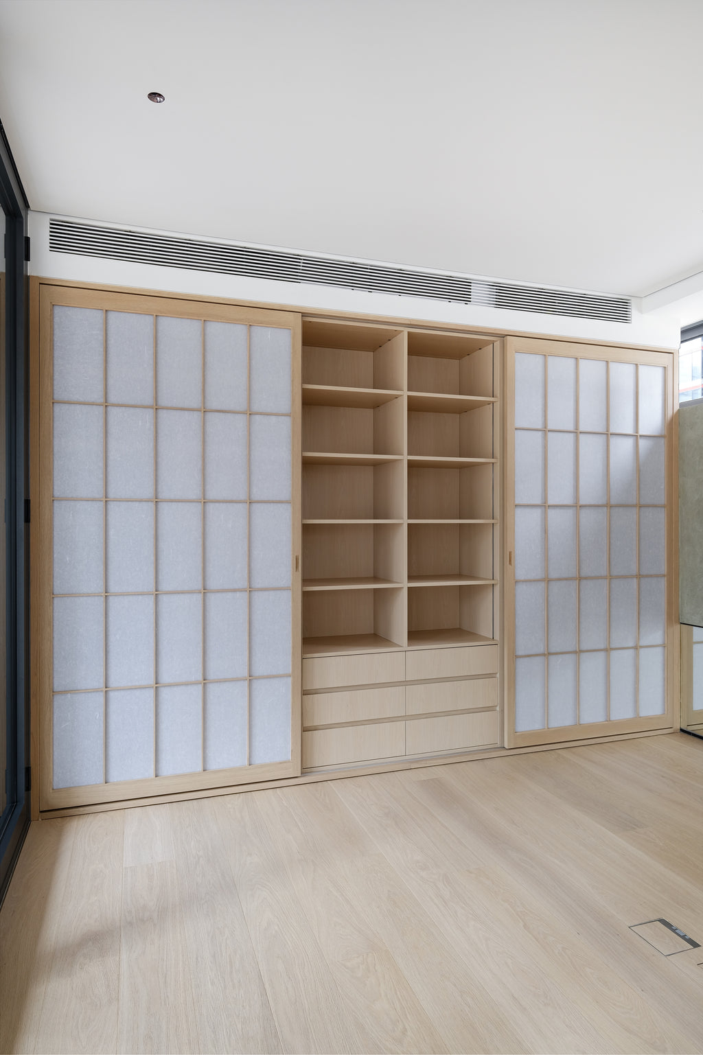 Custom Oak Storage Wall with Translucent Sliding Doors